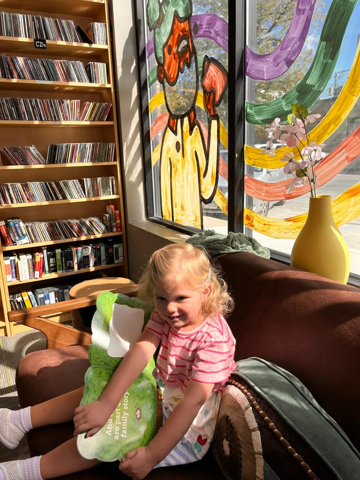 A young visitor browsing books around the central table at the Books4Cause free bookstore